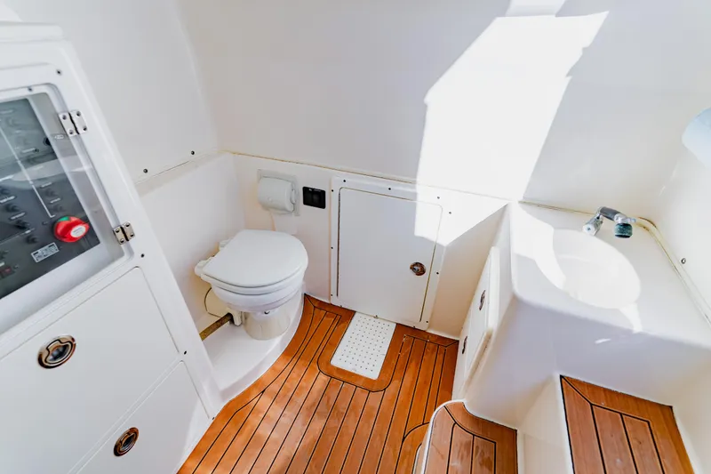 Slide: The Image of 2017 Cobia 344 Center Console boat bathroom with wooden flooring and compact design. - 46