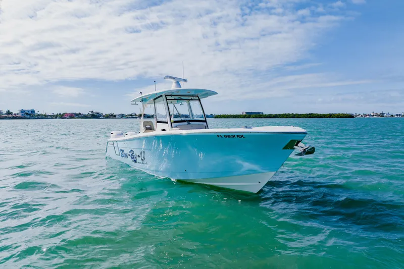 Slide: The Image of 2017 Cobia 344 Center Console boat on clear blue water under a partly cloudy sky. - 6