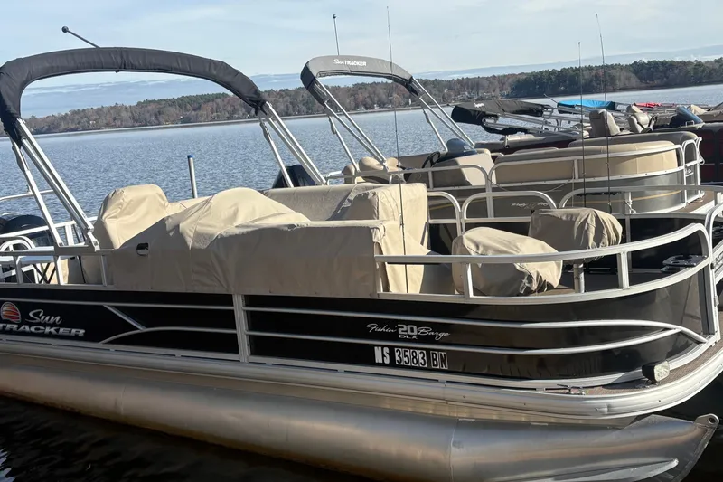 Slide: The Image of 2019 Sun Tracker Fishin' Barge 20 DLX pontoon boat docked on a serene lake. - 3