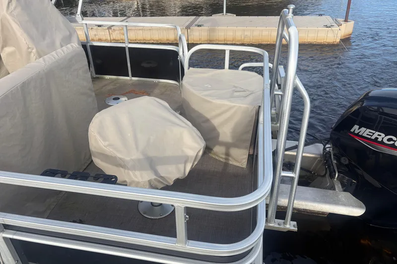 Slide: The Image of 2019 Sun Tracker Fishin' Barge 20 DLX with covered seats and Mercury outboard motor. - 6