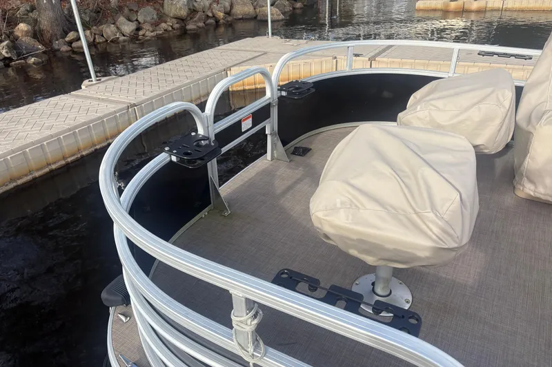 Slide: The Image of 2019 Sun Tracker Fishin' Barge 20 DLX at dock, covered seats, fishing rod holders. - 7