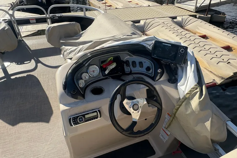 Slide: The Image of 2019 Sun Tracker Fishin' Barge 20 DLX dashboard with steering wheel and navigation equipment. - 9