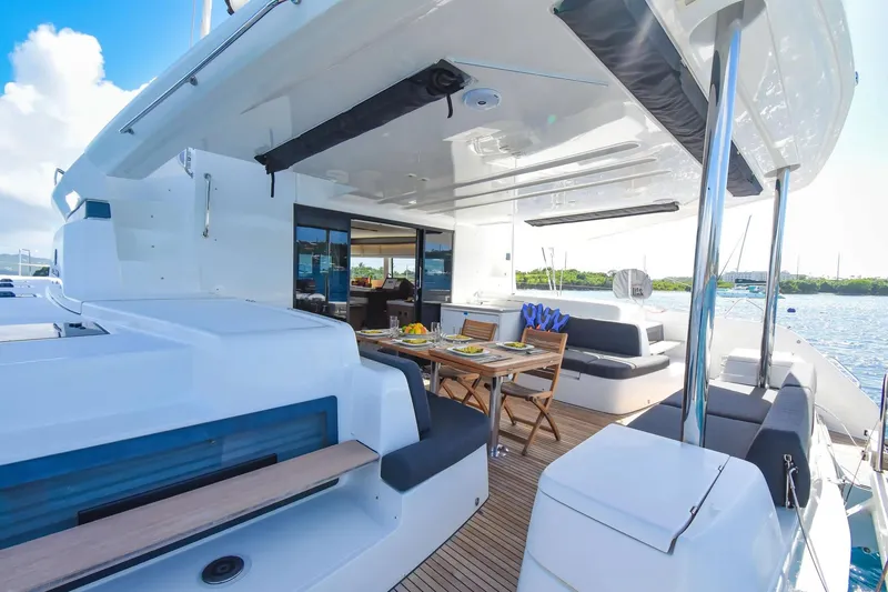 Slide: The Image of Luxurious 2021 Lagoon 50 catamaran with elegant outdoor dining area and scenic ocean view. - 17