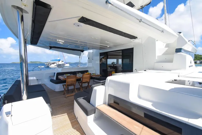 Slide: The Image of Luxurious 2021 Lagoon 50 yacht with spacious deck and dining area, anchored in serene waters. - 18