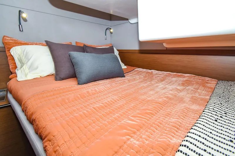 Slide: The Image of Luxurious bedroom interior of 2021 Lagoon 50 yacht with orange bedding and modern lighting. - 19