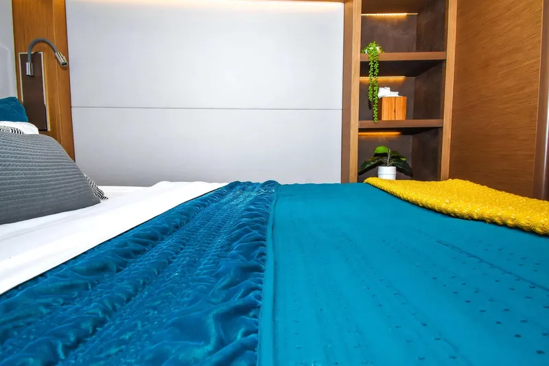 Slide: The Image of Luxurious bedroom interior on 2021 Lagoon 50 yacht with vibrant teal and yellow bedding. - 22