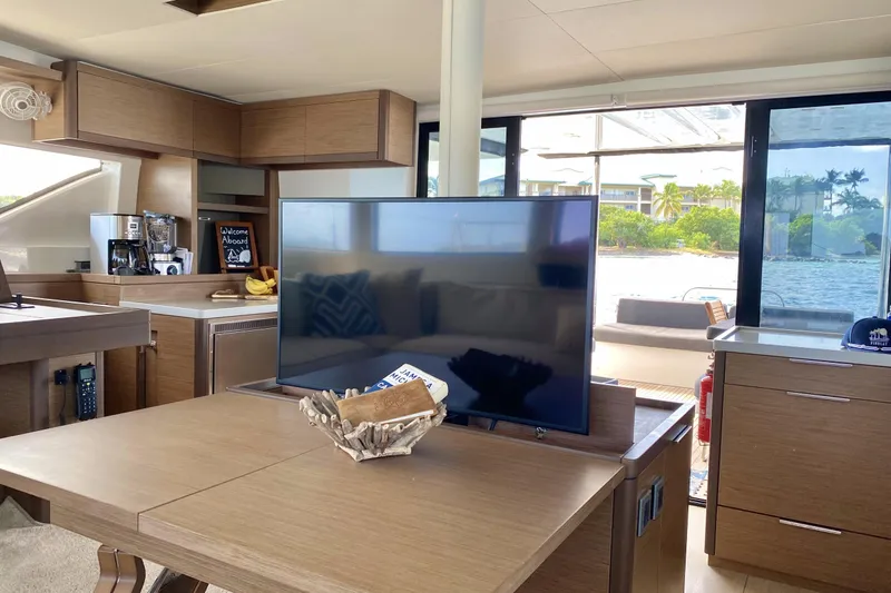 Slide: The Image of Interior of 2021 Lagoon 50 catamaran with modern kitchen and TV, overlooking water. - 37