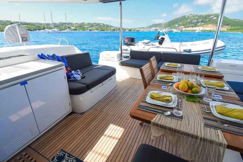 Slide: The Image of Luxurious 2021 Lagoon 50 yacht deck with dining setup, overlooking serene blue waters. - 46