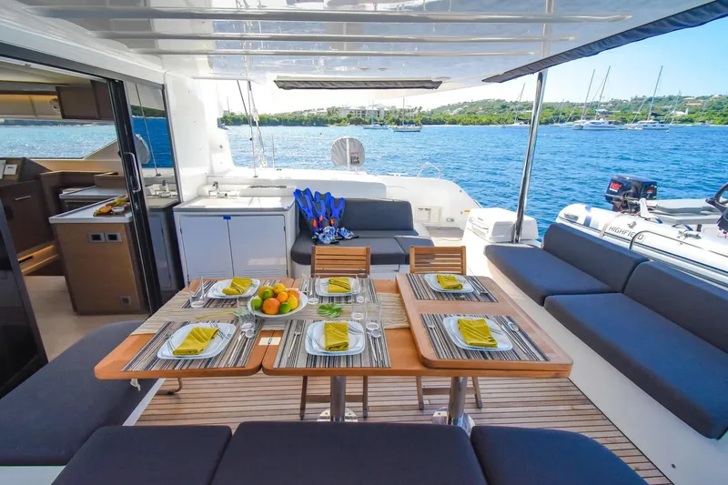 Slide: The Image of Luxurious 2021 Lagoon 50 yacht deck with dining setup, overlooking serene blue waters. - 49
