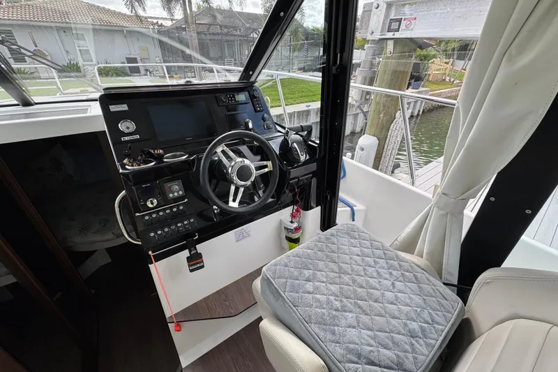 Slide: The Image of 2022 Jeanneau NC Weekender 1095 helm with modern controls and comfortable seating. - 10