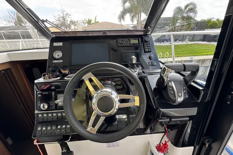 Slide: The Image of Cockpit of 2022 Jeanneau NC Weekender 1095 with steering wheel and control panel. - 11