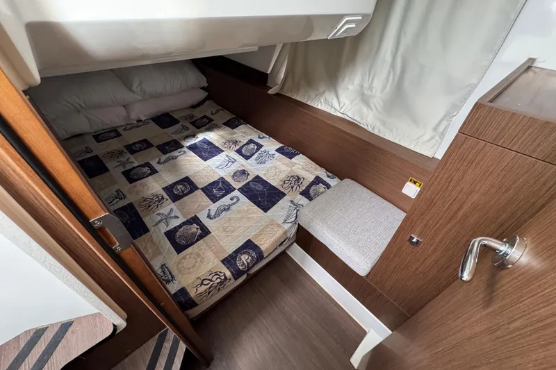 Slide: The Image of Cozy cabin interior of 2022 Jeanneau NC Weekender 1095 with nautical-themed bedding. - 13