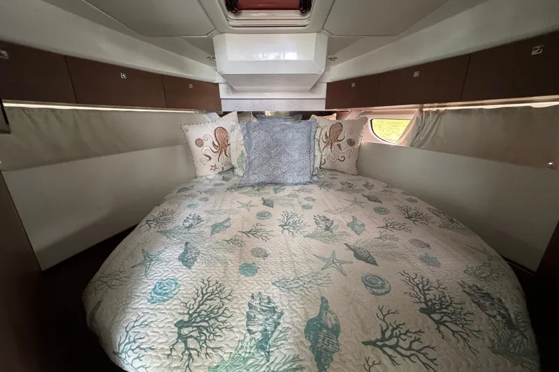 Slide: The Image of Luxurious cabin interior of 2022 Jeanneau NC Weekender 1095 with nautical-themed bedding. - 16