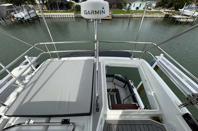 Slide: The Image of 2022 Jeanneau NC Weekender 1095 boat deck with Garmin radar, docked by waterfront homes. - 20