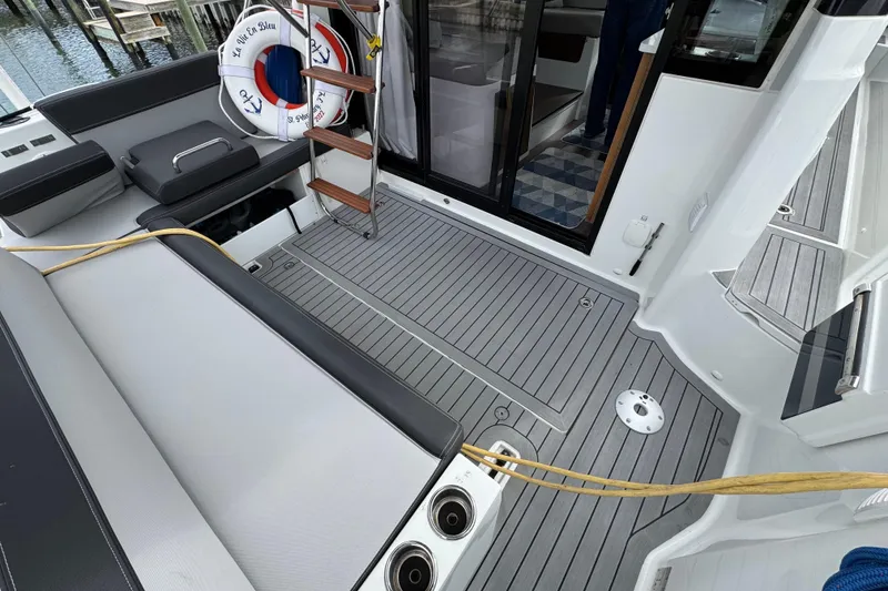 Slide: The Image of 2022 Jeanneau NC Weekender 1095 boat deck with seating, ladder, and life preserver. - 4