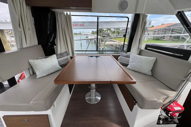 Slide: The Image of Interior of 2022 Jeanneau NC Weekender 1095 with cozy seating and waterfront view. - 7