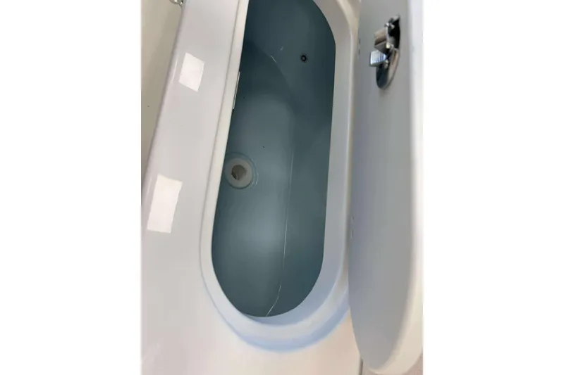 Slide: The Image of 2026 Key West 239 FS boat storage compartment with open lid, showcasing interior space. - 12