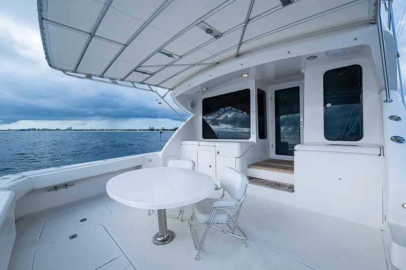 Slide: The Image of 2006 Bertram 630 Convertible yacht deck with table and chairs, overlooking the ocean. - 15