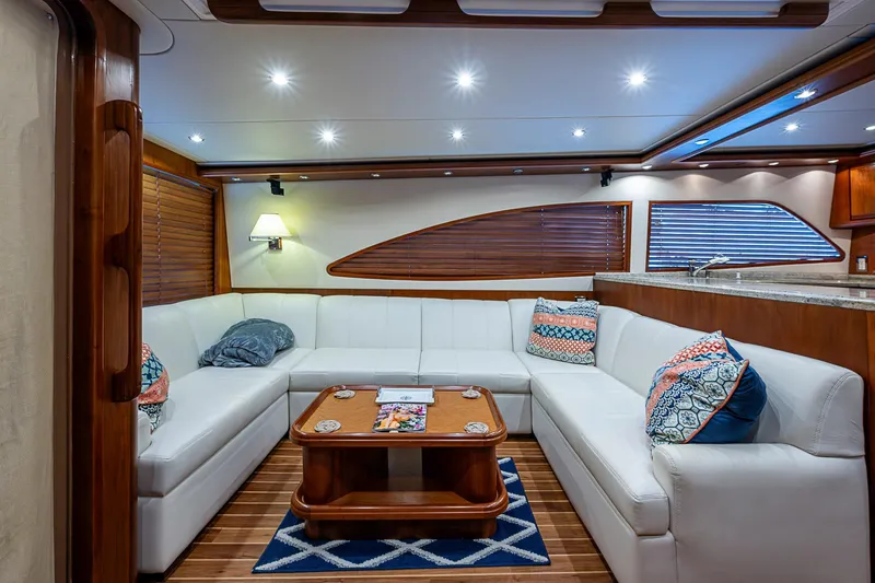 Slide: The Image of Luxurious interior of 2006 Bertram 630 Convertible yacht with white leather seating and wooden accents. - 27