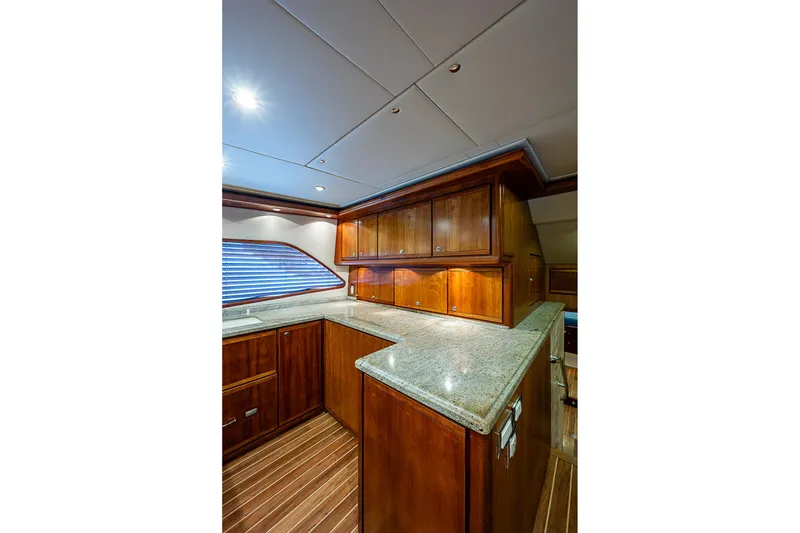 Slide: The Image of Luxurious 2006 Bertram 630 Convertible yacht interior with elegant wood cabinetry and granite countertops. - 37