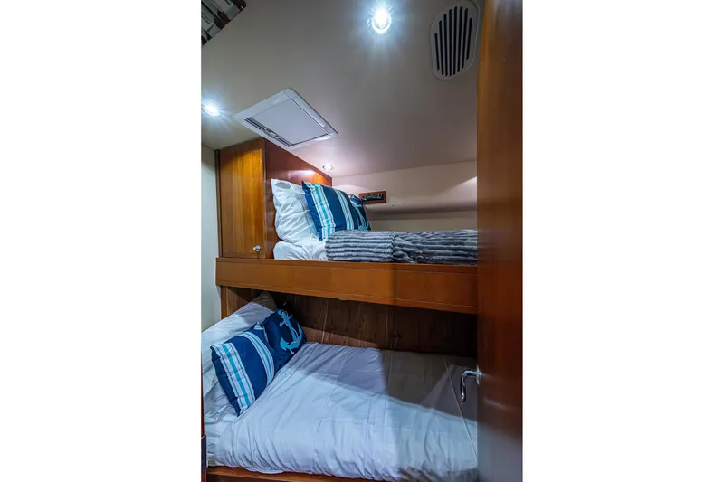 Slide: The Image of Bunk beds in 2006 Bertram 630 Convertible yacht cabin with nautical-themed pillows. - 41