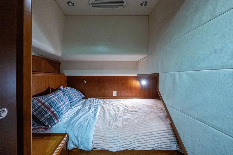 Slide: The Image of Cozy cabin interior of 2006 Bertram 630 Convertible yacht with bed and ambient lighting. - 46