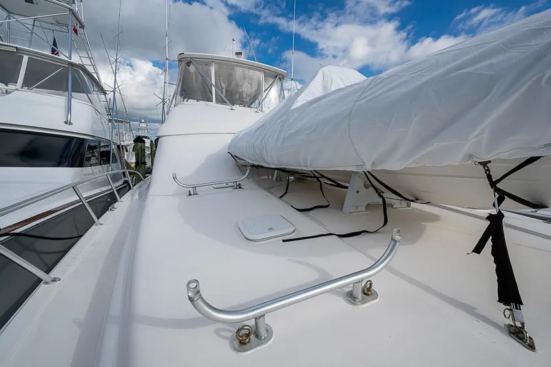 Slide: The Image of 2006 Bertram 630 Convertible yacht deck with covered equipment, under a blue sky. - 51