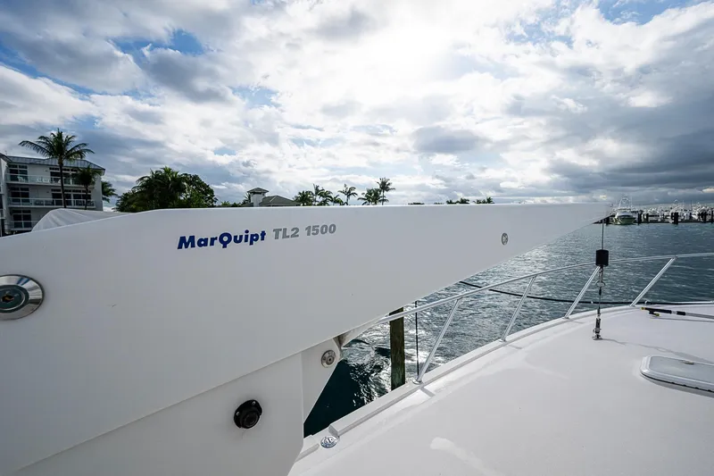 Slide: The Image of Bertram 630 Convertible 2006 yacht with MarQuipt TL2 1500 crane, docked under cloudy sky. - 52