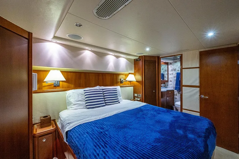 Slide: The Image of Luxurious bedroom interior of 2006 Bertram 630 Convertible yacht with blue bedding. - 55