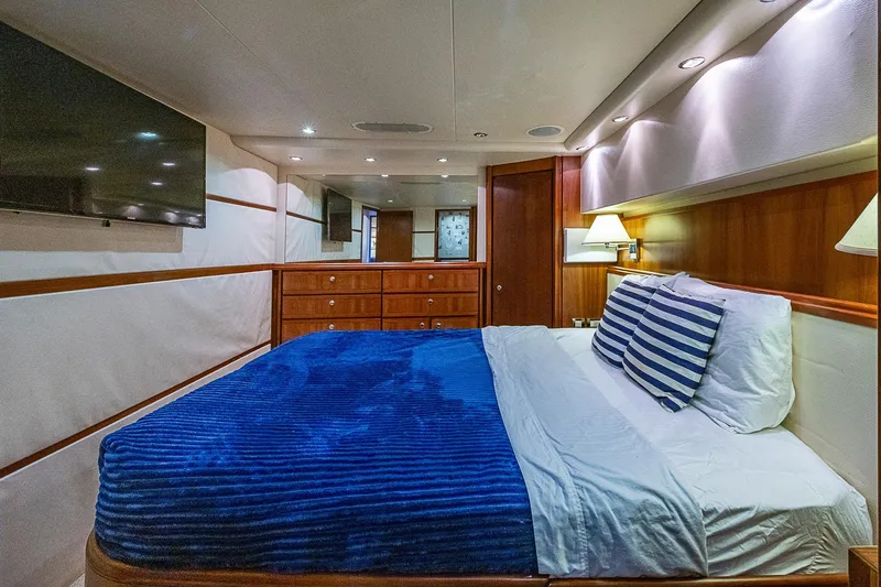 Slide: The Image of Luxurious bedroom interior of 2006 Bertram 630 Convertible yacht with blue bedding and wood accents. - 59