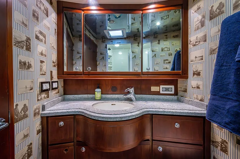 Slide: The Image of Luxurious bathroom in 2006 Bertram 630 Convertible yacht with elegant wood cabinetry and vintage wallpaper. - 60