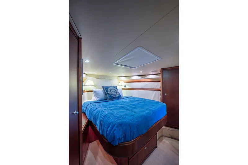 Slide: The Image of Luxurious cabin interior of 2006 Bertram 630 Convertible yacht with blue bedding. - 62