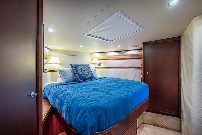 Slide: The Image of Luxurious bedroom interior of 2006 Bertram 630 Convertible yacht with blue bedding. - 63