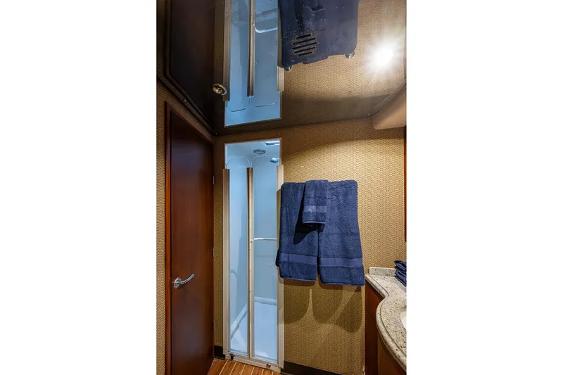 Slide: The Image of Bathroom interior of 2006 Bertram 630 Convertible yacht with shower and blue towels. - 68