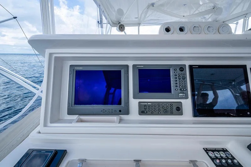 Slide: The Image of Control panel of a 2006 Bertram 630 Convertible yacht with navigation screens. - 78