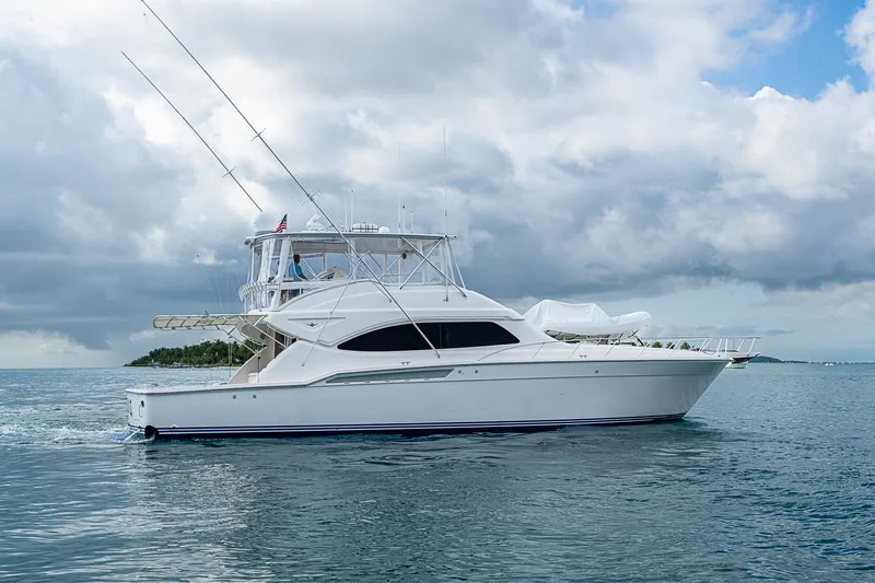 Slide: The Image of 2006 Bertram 630 Convertible yacht cruising on calm ocean waters under cloudy skies. - 8