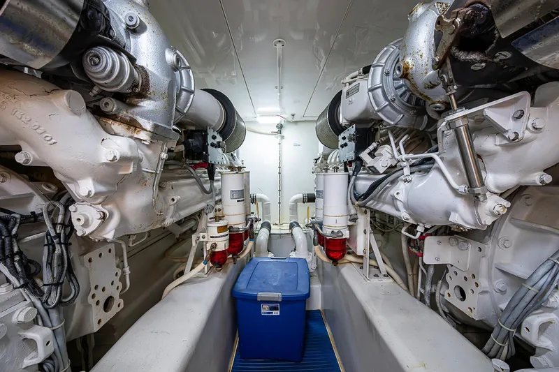 Slide: The Image of Engine room of 2006 Bertram 630 Convertible yacht, featuring dual engines and storage container. - 87