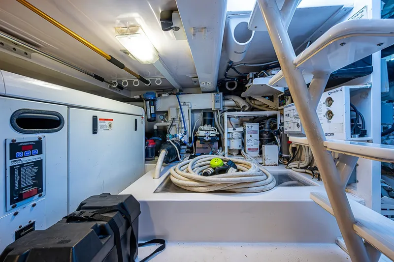 Slide: The Image of Engine room of 2006 Bertram 630 Convertible yacht, featuring equipment and hoses. - 93