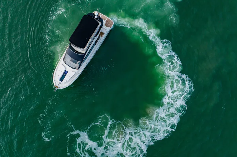 Slide: The Image of Aerial view of 2015 Monte Carlo MC5 yacht making a circular wake in green water. - 10