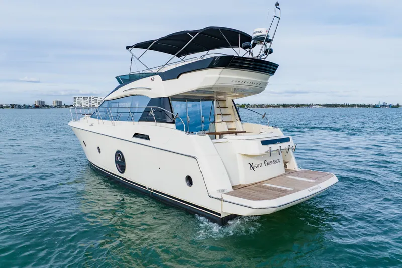 Slide: The Image of 2015 Monte Carlo MC5 yacht cruising on open water, featuring sleek design and spacious deck. - 8