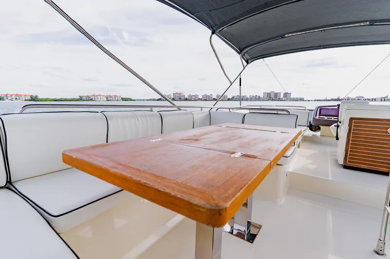 Slide: The Image of Luxurious 2015 Monte Carlo MC5 yacht interior with wooden table and white seating. - 80