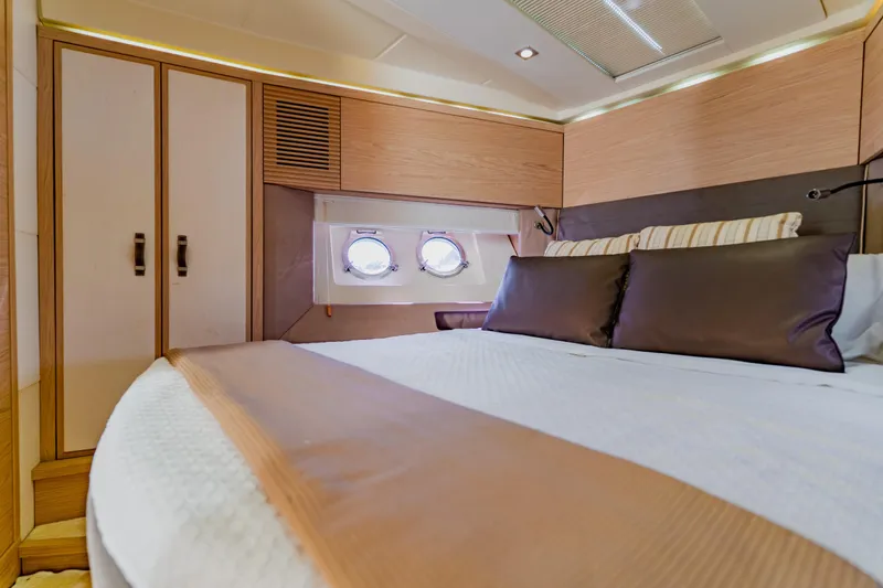 Slide: The Image of Luxurious Monte Carlo MC5 2015 yacht cabin with elegant bedding and porthole windows. - 44