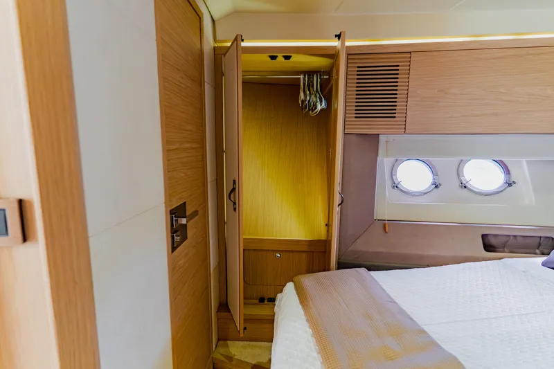 Slide: The Image of Luxurious Monte Carlo MC5 2015 yacht bedroom with wooden closet and porthole windows. - 49