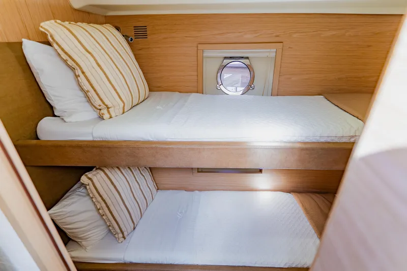 Slide: The Image of Cozy twin bunk beds in 2015 Monte Carlo MC5 yacht cabin with porthole. - 51