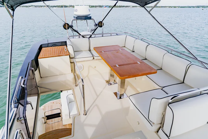 Slide: The Image of Luxurious 2015 Monte Carlo MC5 yacht deck with seating and table on calm water. - 78