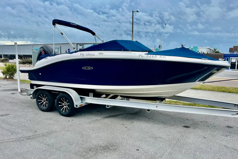 The Image of 2018 Sea Ray SPX 190 Outboard boat on trailer, blue hull, parked outdoors. - 0