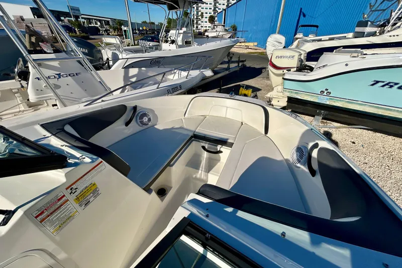 Slide: The Image of 2018 Sea Ray SPX 190 Outboard boat interior with seating and speakers at a marina. - 8
