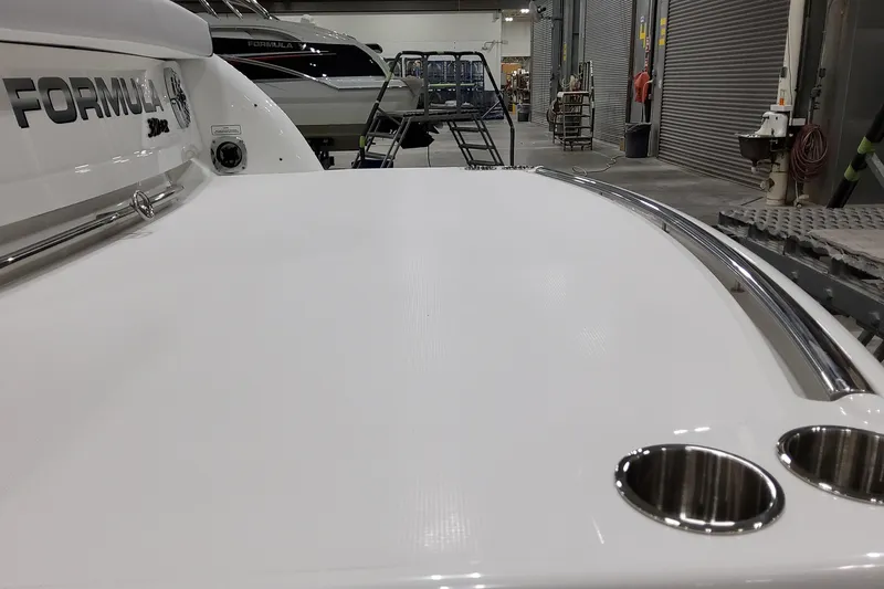 Slide: The Image of 2026 Formula 310 Bowrider I/O boat in showroom, showcasing sleek design and stainless steel features. - 11