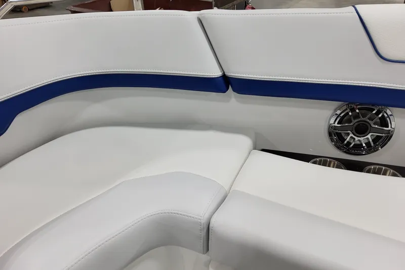 Slide: The Image of 2026 Formula 310 Bowrider I/O interior with white and blue seating, speaker, and cup holders. - 24