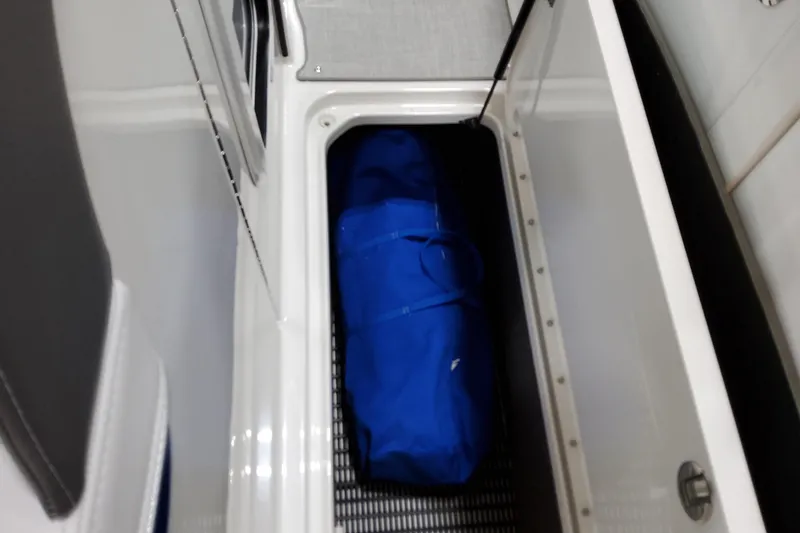 Slide: The Image of Storage compartment in 2026 Formula 310 Bowrider I/O with blue bag inside. - 38
